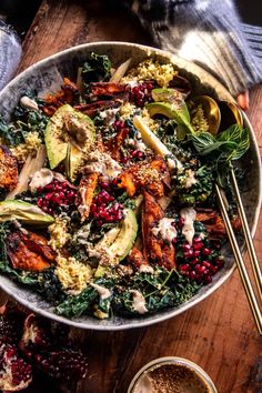 a large bowl filled with food on top of a wooden table next to a cup of coffee