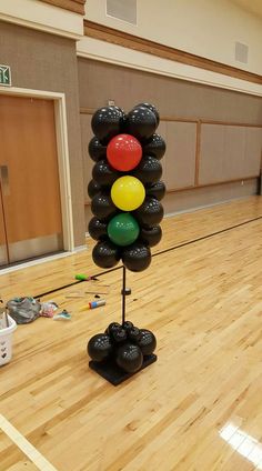 a bunch of balloons that are on top of a pole in the middle of a gym