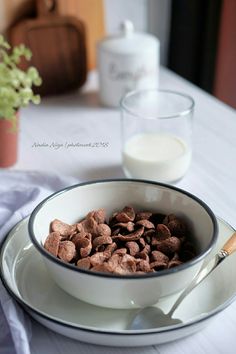 a bowl of cereal and milk on a table