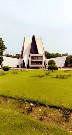 a large building sitting on top of a lush green field