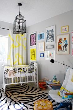 a baby's room with zebra print rug and yellow curtains