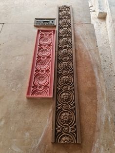 two decorative molds sitting next to each other on the floor in front of a building