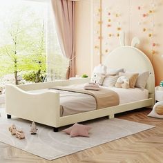 a child's bedroom with pink walls and white furniture, including a large bed