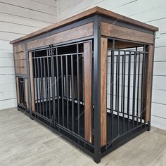 a wooden dog crate sitting on top of a hard wood floor next to a white wall