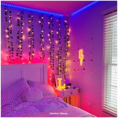 a bedroom decorated in pink and purple with string lights on the wall above the bed