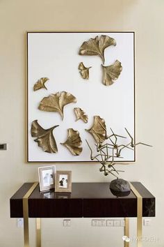 a table with some pictures on it and a plant in front of the wall above it