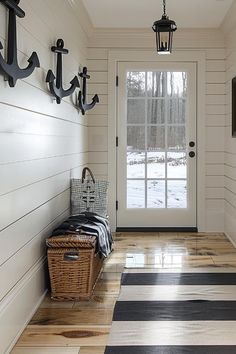 an entryway with black and white striped flooring, coat hooks on the wall