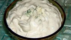 a bowl filled with white sauce sitting on top of a table