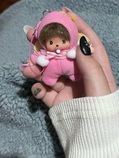 a person holding a small doll in their hand