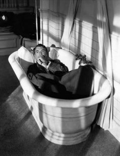 a man laying in a bathtub with his mouth open