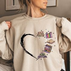 "Book Lover Sweatshirt, Heart Themed Book T-Shirt, Librarian Shirt, Reading Shirt, Gift For Librarian, Bookworm Shirt, Gift For Book Lover Thank you so much for taking the time to browse my shop. Please feel free to reach out if you have any questions before or after purchasing.  💖 🎨Warning: On products with a print chart in the listing, metallic print colors are printed as matte.✨✌ We design and cut each graphic out with a soft touch, use matte vinyl and a heat press. The result will last for Booktok Questions, Book Tshirt Design, Bookworm Clothes, Nerd Tshirts, Gift For Librarian, Bookworm Shirt, Book Tracker, Librarian Shirt