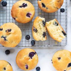 blueberry muffins cooling on a wire rack with fresh blueberries around them