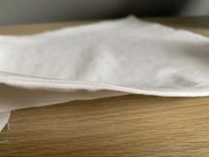 a piece of white cloth sitting on top of a wooden table