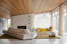 a modern living room with white walls and wood ceiling