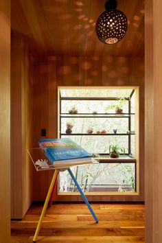 a room with wooden walls and flooring has a lamp hanging from the ceiling above it