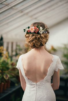 the back of a bride's dress with flowers in her hair