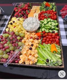 a platter with grapes, celery, cucumbers, and other fruits