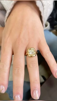 a close up of a person's hand with a ring on it