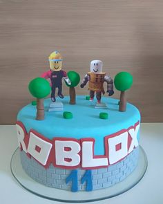 a cake with two figures on top and the words robblox spelled in large letters