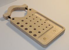 a wooden cutting board with holes on the front and back sides, sitting on a white surface