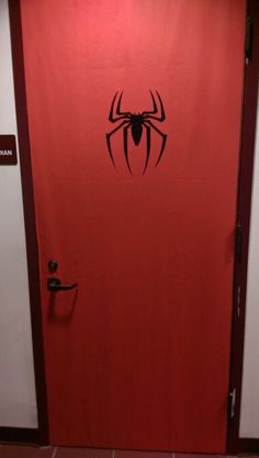 a red door with a black spider logo on it