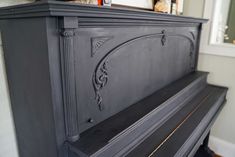 a black painted fireplace with ornate carvings on the mantle