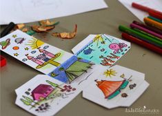 children's drawings and colored pencils on a table