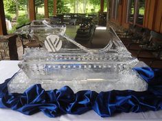 an ice sculpture is sitting on a table in front of some chairs and tables outside