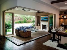 a living room with wood flooring and large sliding glass doors leading to an outdoor patio