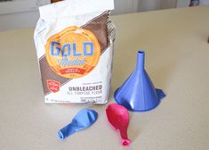 two plastic funnels sitting on top of a counter next to a bag of cereal