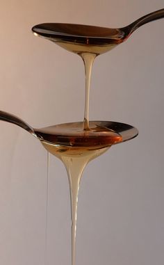 two spoons pouring liquid onto each other