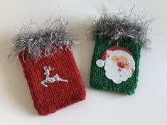 two knitted christmas stocking holders with silver tinsel on the top and santa clause on the bottom