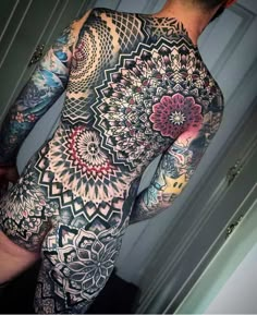 the back of a man's full body covered in tattoos