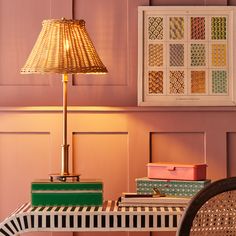 a lamp sitting on top of a table next to a chair and pictures above it