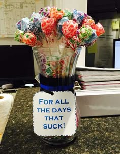 a vase filled with lots of candy sitting on top of a counter