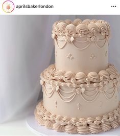 three tiered wedding cake with intricate designs on it's sides and the words apprisbaker london