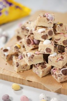 a wooden cutting board topped with lots of candy and marshmallows on top of it