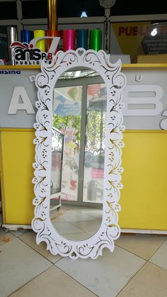 a white mirror sitting on top of a tiled floor next to a yellow and white counter