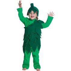 a little boy dressed in a green tinkerbell costume and holding his hands up