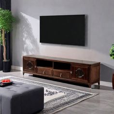 a living room with a couch, coffee table and television on the wall in front of it