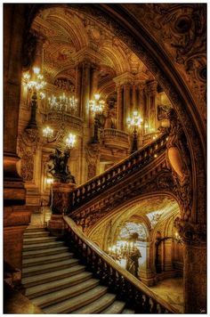 an ornate staircase and chandelier in a building