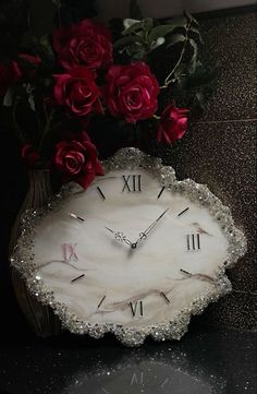 a clock with roses in it sitting on a table