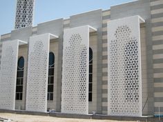 a tall building with white lattice work on it's sides and windows next to a clock tower