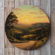 a painting on the wall of a wooden fence with a sunset in the valley behind it