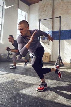 two men in a gym doing exercises on exercise balls with one man running behind them