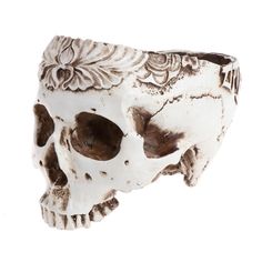 a white and brown skull vase sitting on top of a table