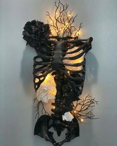 the skeleton is decorated with lights and flowers on it's back end, as well as some branches