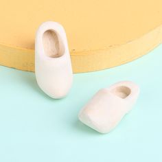 two white shoes sitting on top of a blue and yellow table next to a round object