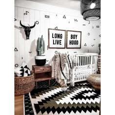 a baby's room with two pictures on the wall and a black and white rug