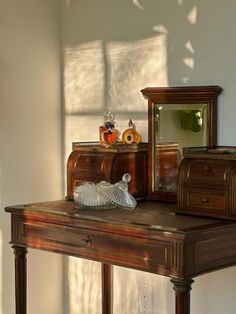 an old wooden desk with several pieces of furniture sitting on it's top shelf